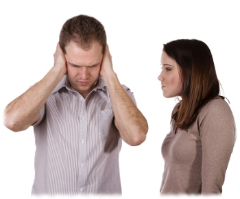 Man shutting his ears and not listening to the persistent yelling of his spouse